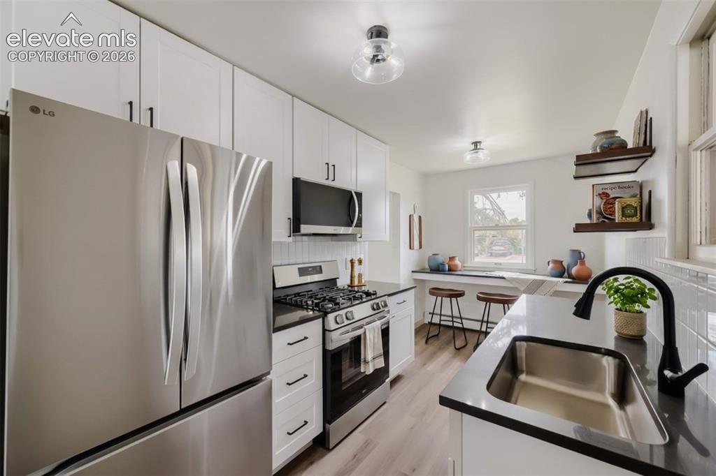 Image 10 of 41: Stainless steel refrigerator, gas range with oven, built-in microwave, whit