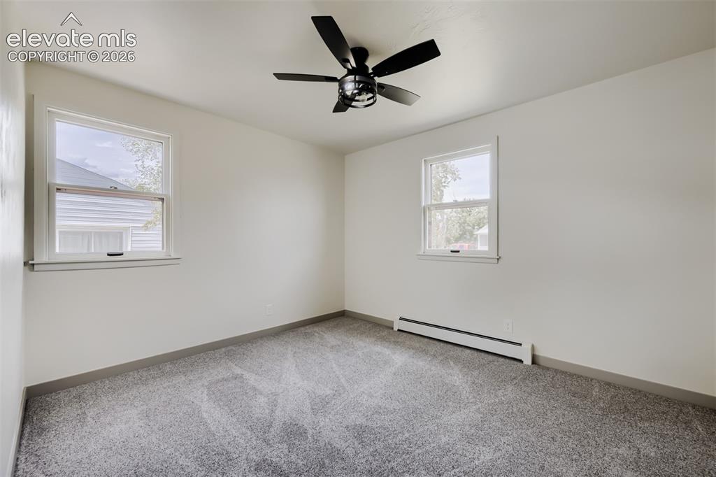 Image 15 of 41: Bright, light-filled bedroom with dual windows providing natural illuminati