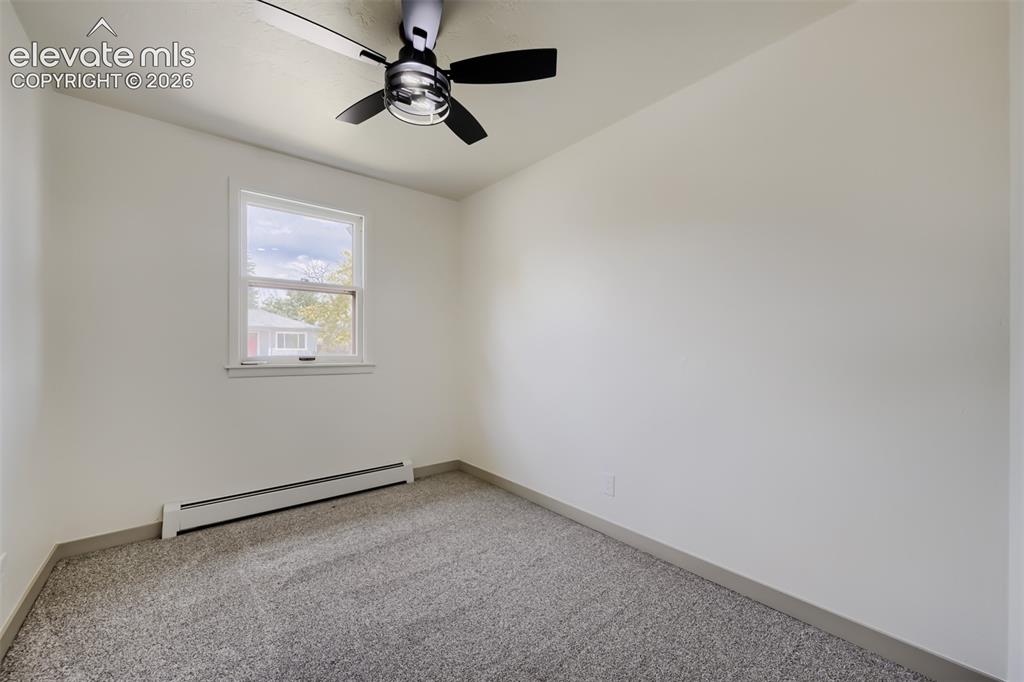 Image 19 of 41: Neutral wall paint with gray carpeting, featuring a ceiling fan with black 