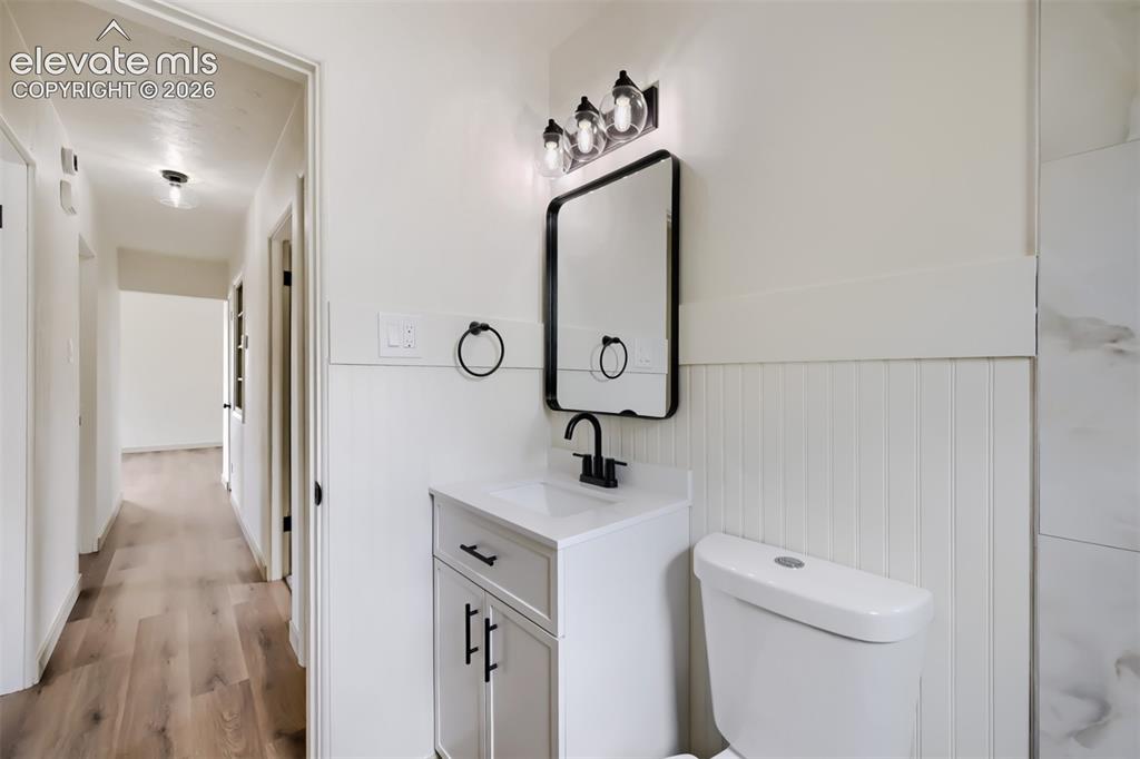 Image 22 of 41: Vanity with integrated sink, black-framed mirror, three-light vanity fixtur