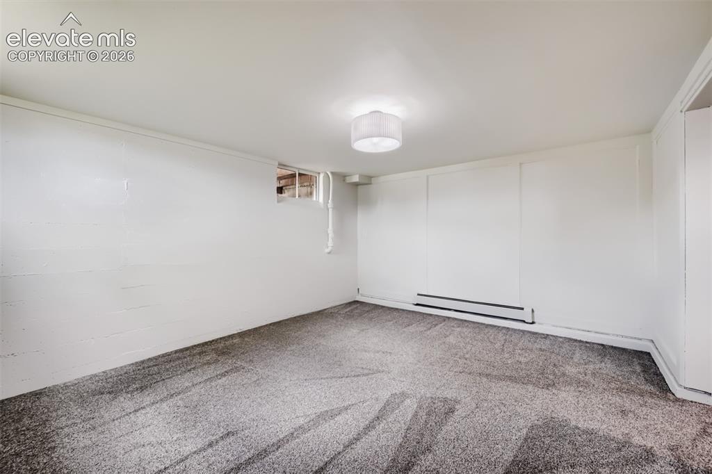 Image 30 of 41: Textured gray carpeting, white painted walls, ceiling-mounted light fixture