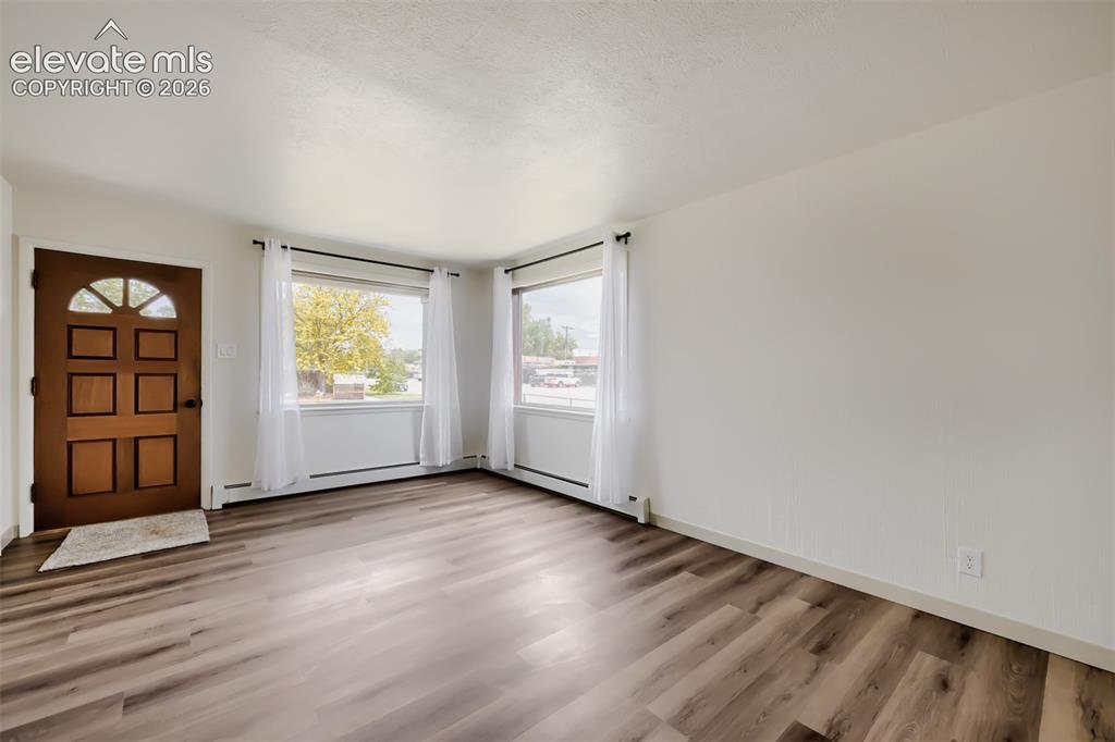 Image 5 of 41: Wood-finish flooring throughout, multiple pane windows, and a panel door wi
