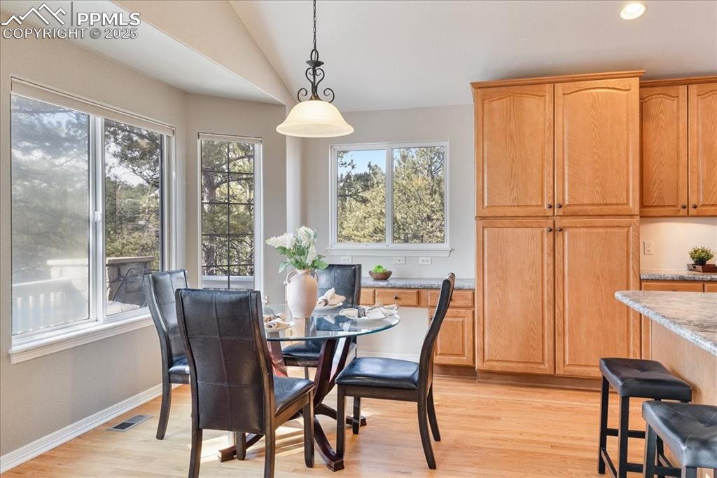 Image 10 of 46: Dining room featuring light wood-style floors and lofted ceiling