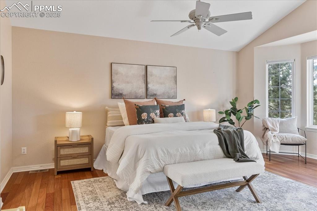 Image 13 of 46: Bedroom with vaulted ceiling, wood finished floors, and a ceiling fan