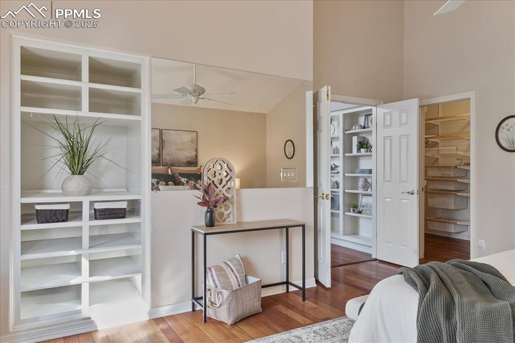 Image 15 of 46: Home office featuring ceiling fan, wood finished floors, and built in shelv