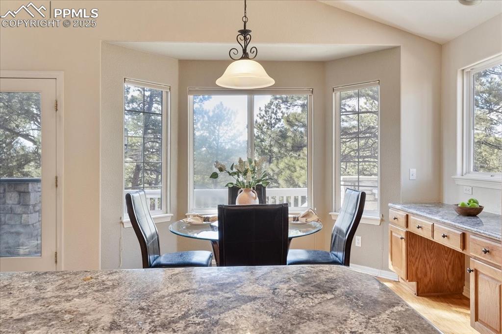 Image 9 of 46: Dining space with light wood-style flooring and lofted ceiling