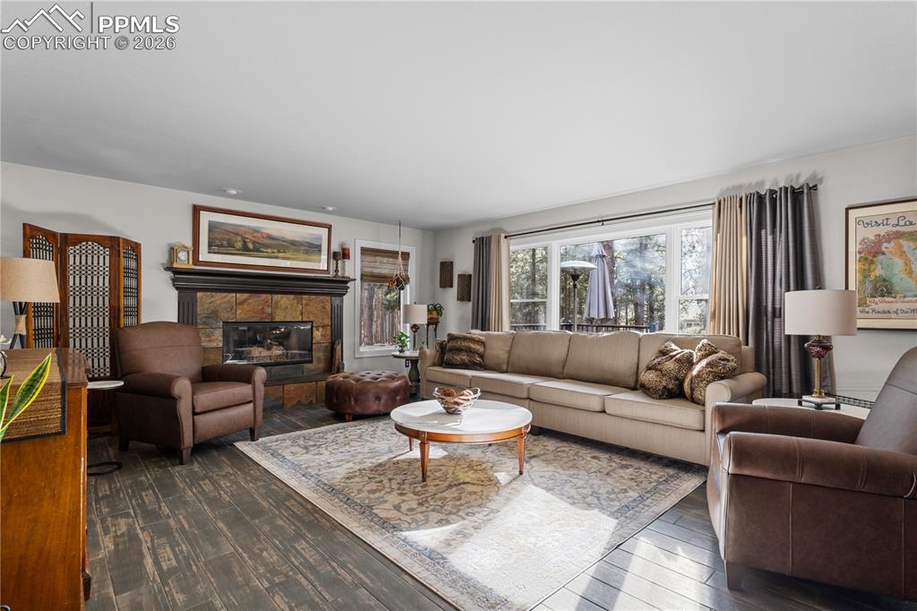 Image 15 of 38: Family room with big bright windows and a gas fireplace, you will want to r