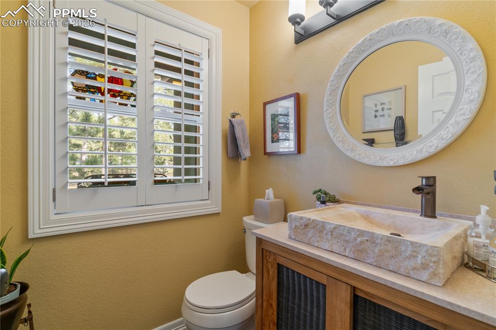 Image 19 of 38: Main level powder bath with custom vanity and shutters.