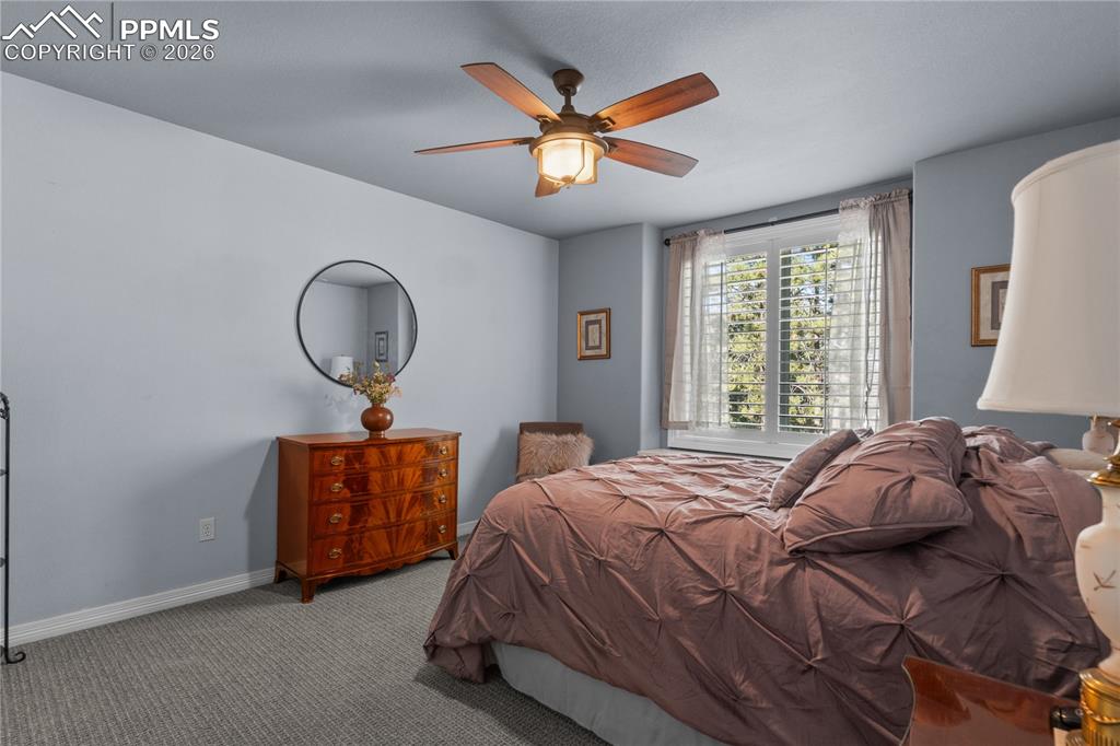 Image 30 of 38: Additional upper level bedroom with ceiling fan.