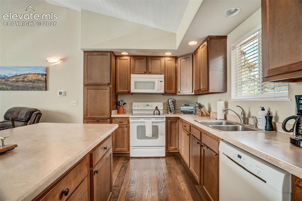 Image 12 of 50: Kitchen featuring wood-finish cabinetry, light-toned countertops, and wood-