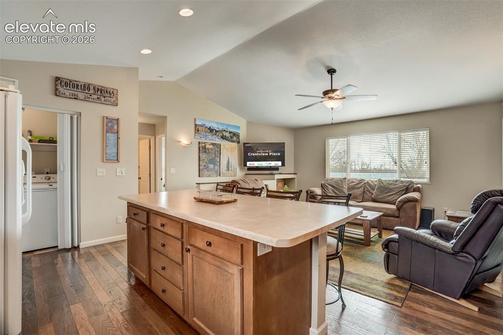 Image 16 of 50: Kitchen island with light-toned countertop and wood cabinetry