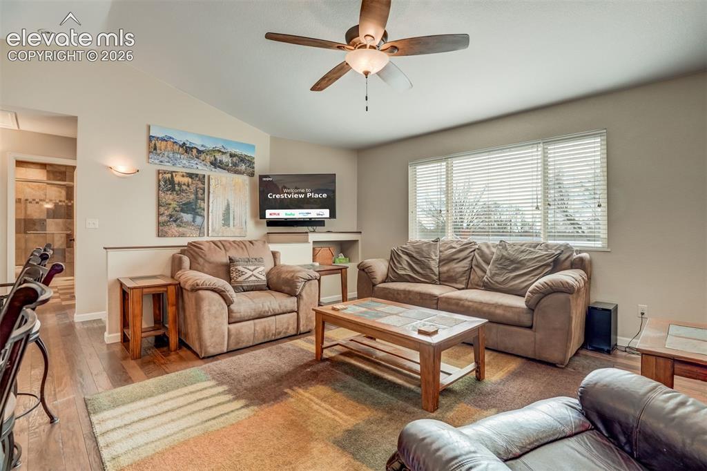 Image 17 of 50: Vaulted ceiling with a ceiling fan, wood-finish flooring, and natural light