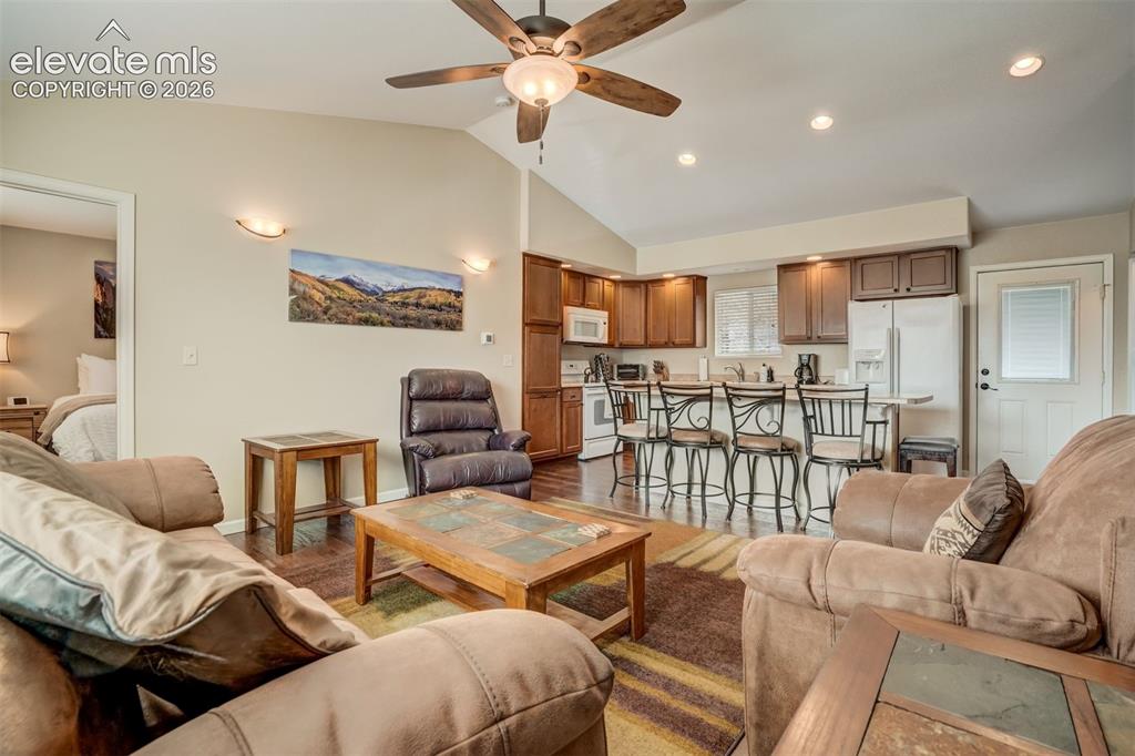 Image 19 of 50: Vaulted ceiling with a ceiling fan, recessed lighting, and wood-finish floo
