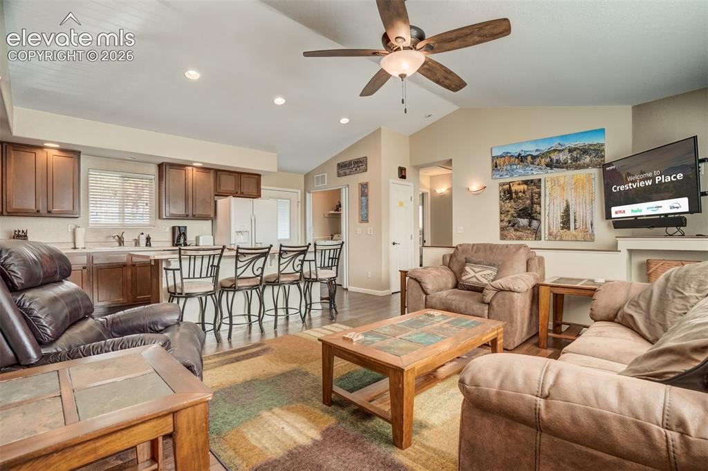 Image 20 of 50: Open-concept living space featuring wood-finish flooring, vaulted ceiling, 