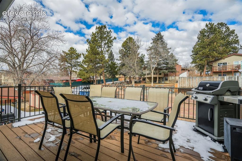 Image 22 of 50: Expansive outdoor deck featuring wood-finish flooring, black metal railing,