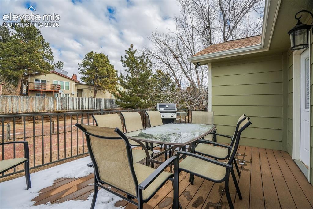 Image 23 of 50: Expansive exterior deck featuring wood-finish decking and a black metal rai