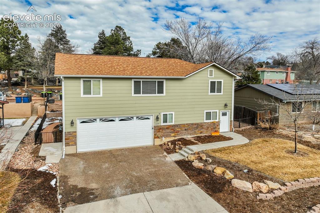 Image 3 of 50: Two-story residence featuring light green siding and a brown shingle roof