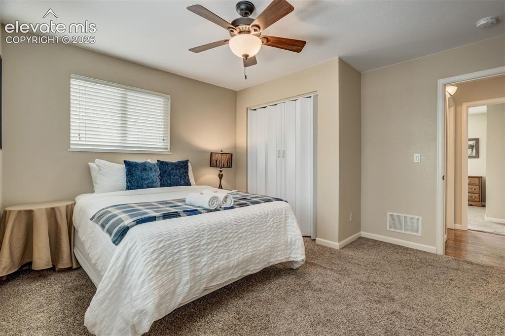 Image 35 of 50: Neutral-toned walls, textured carpeting, ceiling fan with light fixture, wi