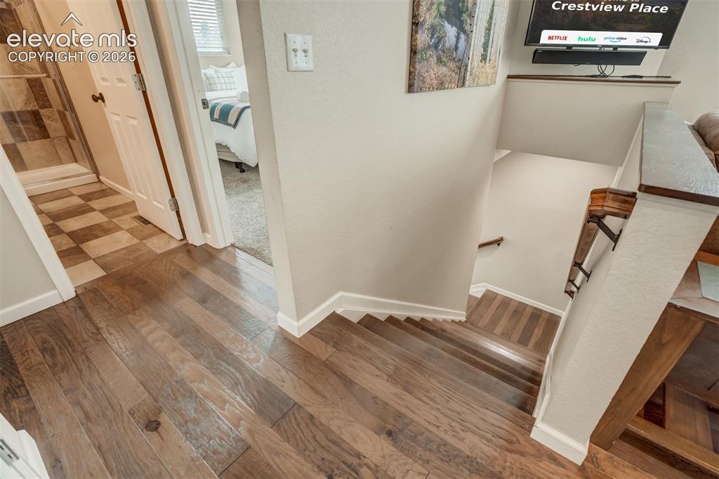 Image 38 of 50: Wood-finish flooring throughout the hallway and stairs