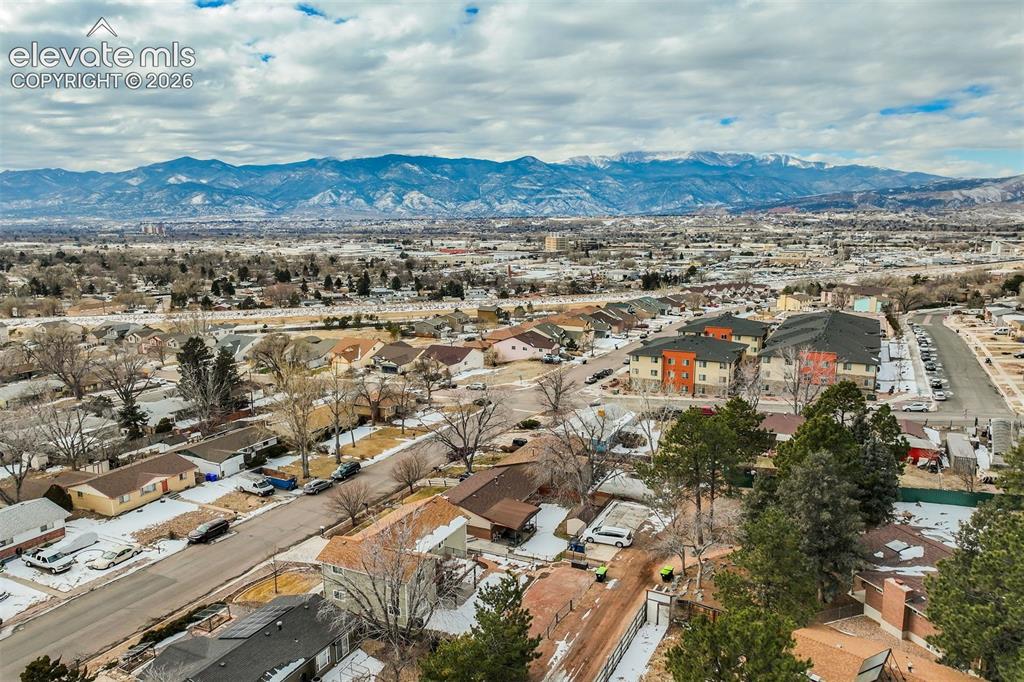 Image 47 of 50: Mountain backdrop with a residential area and distant urban landscape