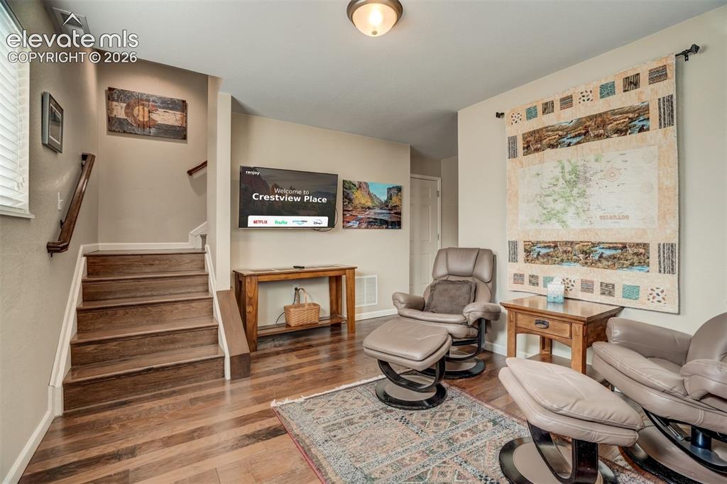 Image 7 of 50: Wood-finish flooring throughout, with a matching wood-finish staircase and