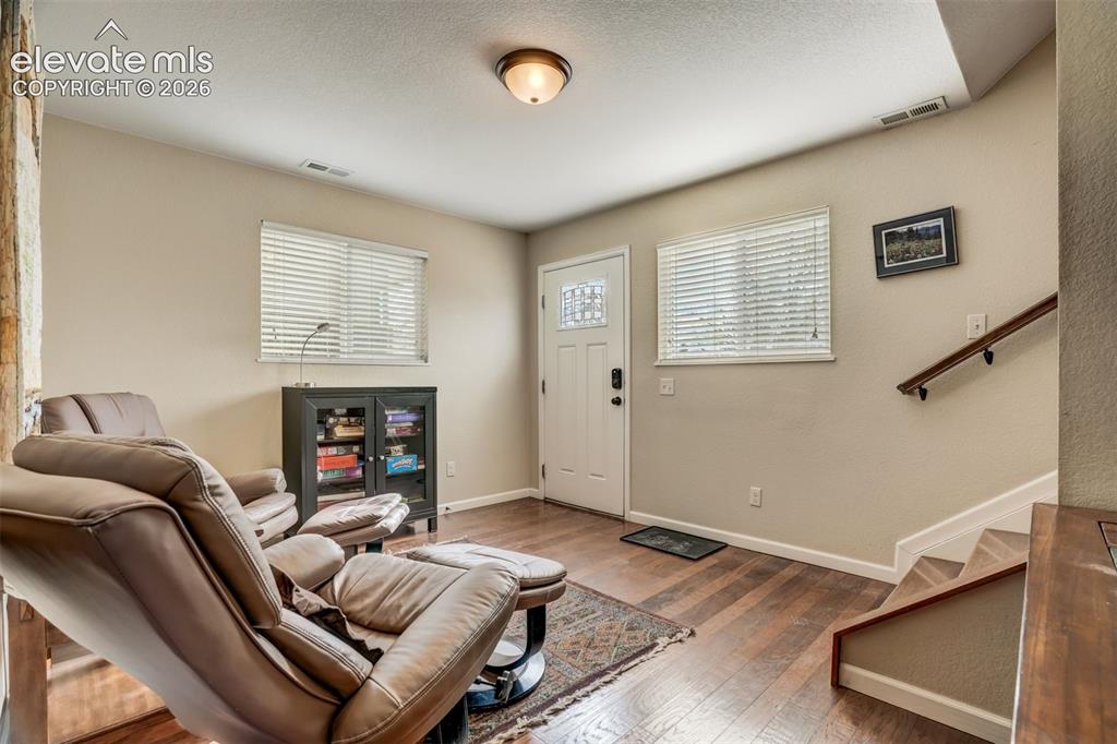 Image 9 of 50: Wood-finish flooring, white paneled door with decorative glass, and a built
