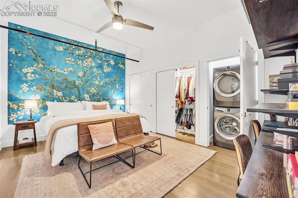 Image 10 of 48: Bedroom with ceiling fan, light wood-type flooring, stacked washer and clot