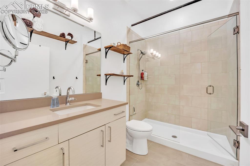 Image 15 of 48: Full bathroom with a stall shower, vanity, toilet, and tile patterned floor