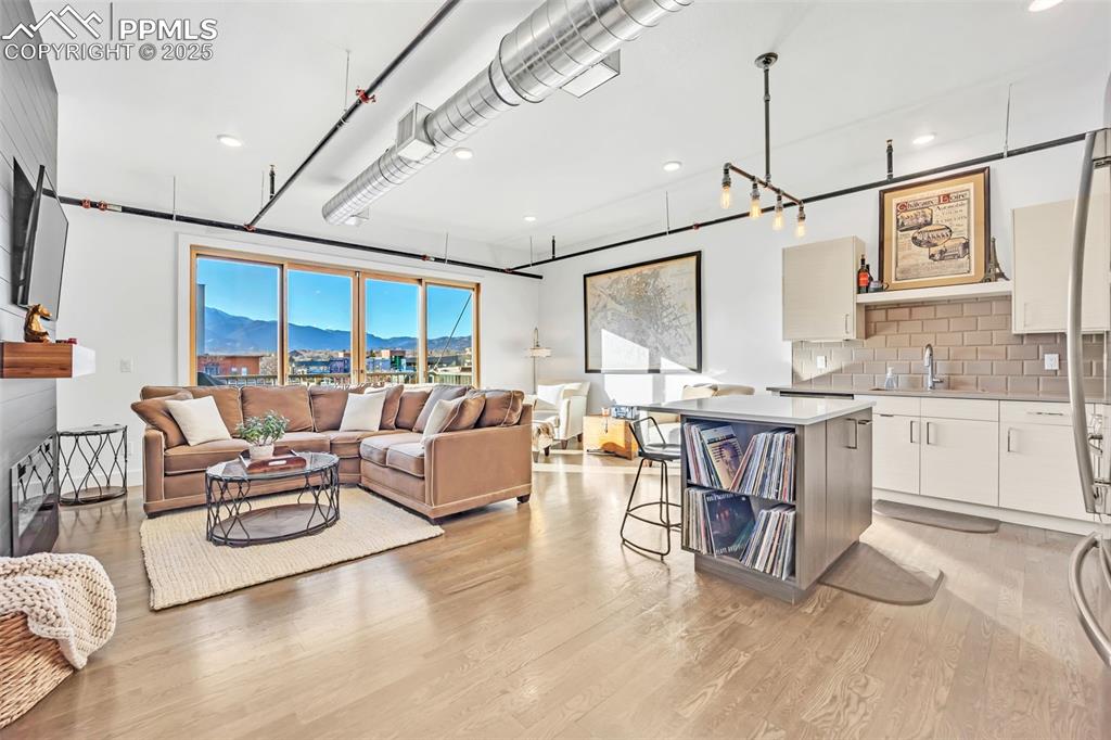 Image 16 of 48: Living room with light wood finished floors and a mountain view