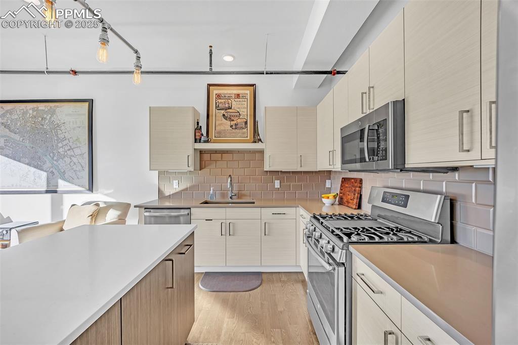 Image 21 of 48: Kitchen with appliances with stainless steel finishes, a sink, light counte