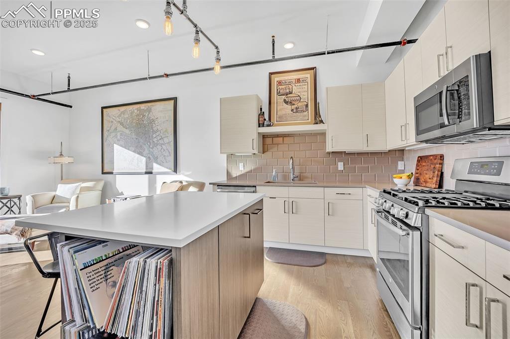 Image 22 of 48: Kitchen featuring a sink, light countertops, appliances with stainless stee