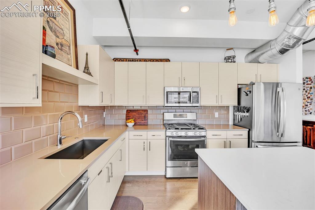 Image 23 of 48: Kitchen featuring light wood finished floors, light countertops, decorative