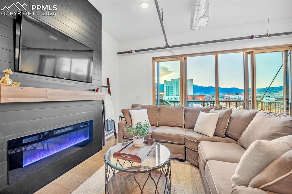 Image 24 of 48: Living area with a mountain view, a city view, wood finished floors, and a