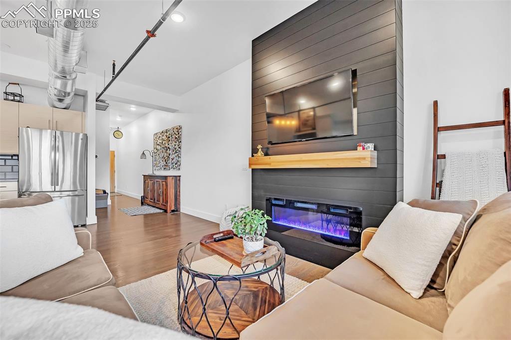 Image 25 of 48: Living room featuring wood finished floors, recessed lighting, a glass cove