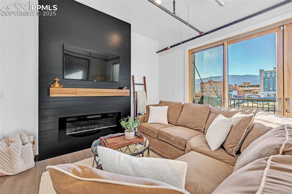 Image 26 of 48: Living area with a fireplace and wood finished floors