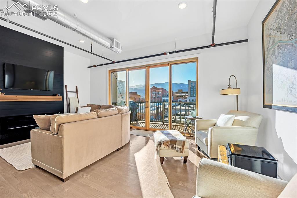 Image 28 of 48: Living room with light wood finished floors, recessed lighting, a mountain