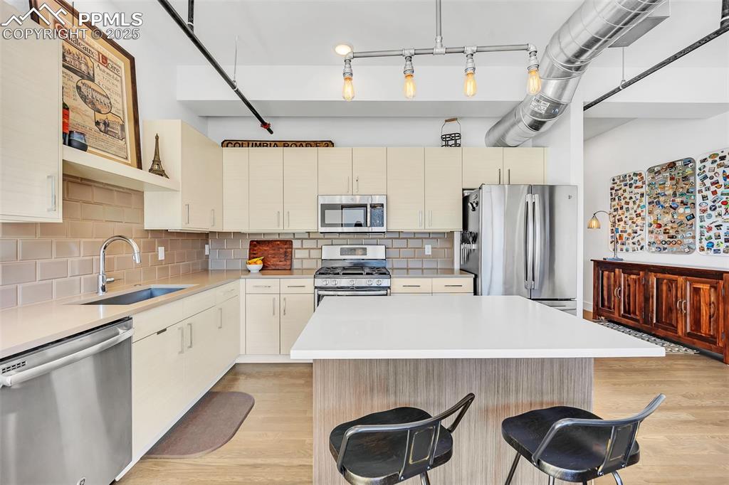 Image 30 of 48: Kitchen featuring cream cabinets, stainless steel appliances, a sink, and l