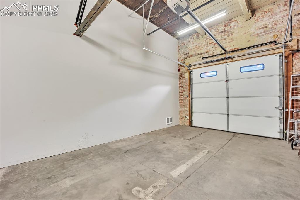Image 41 of 48: Garage featuring visible vents and a garage door opener