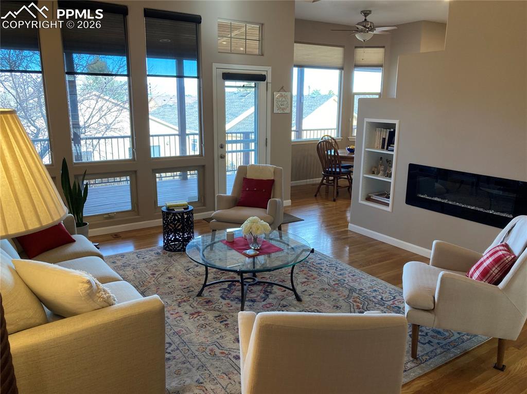 Image 2 of 12: Living room with beautiful hardwood floors, new electric fireplace & large 