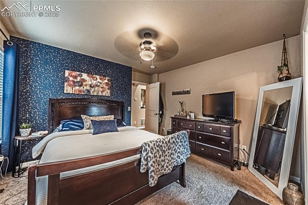 Image 15 of 36: Bedroom featuring ceiling fan, light colored carpet, a textured ceiling, an