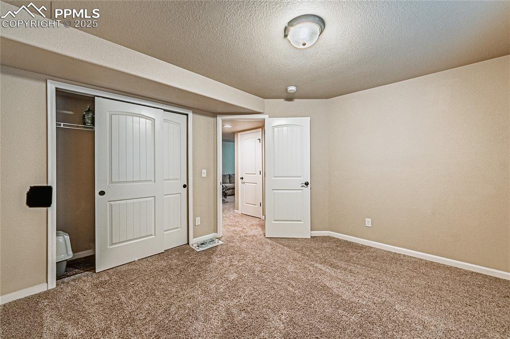 Image 20 of 36: Unfurnished bedroom featuring carpet floors, a closet, and a textured ceili