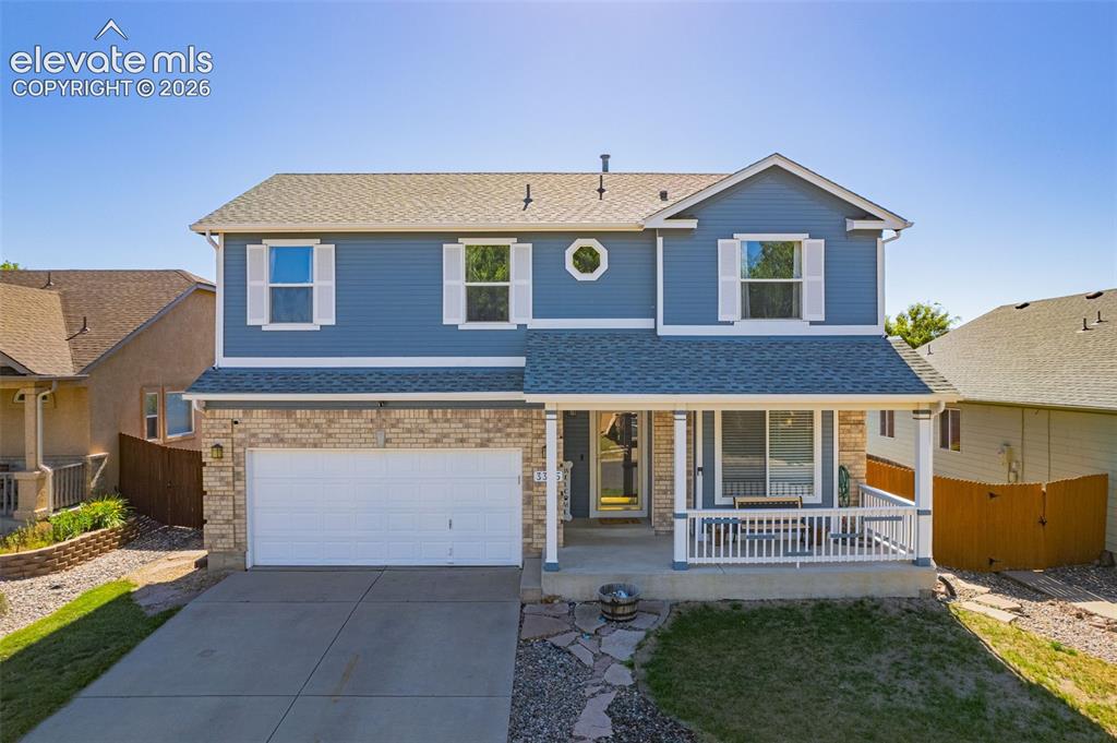 Image 1 of 42: Two-story residence featuring a covered front porch with white railing, blu
