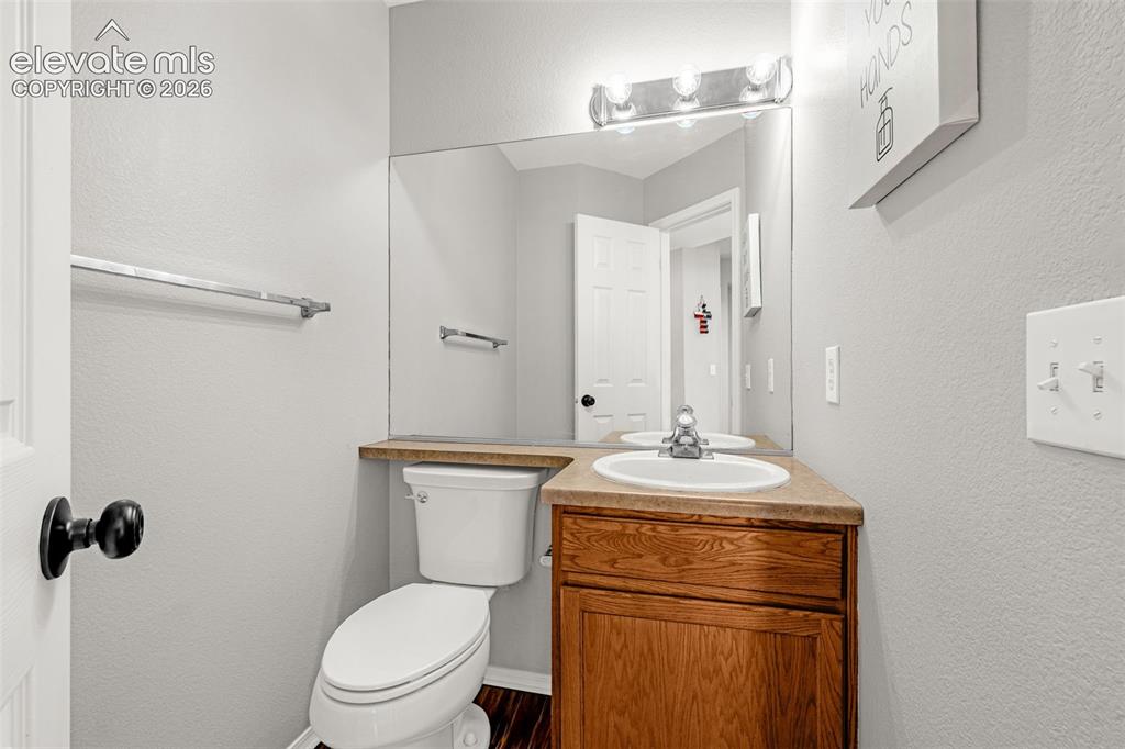 Image 14 of 42: Bathroom featuring a wood-finish vanity with an integrated sink, a large wa