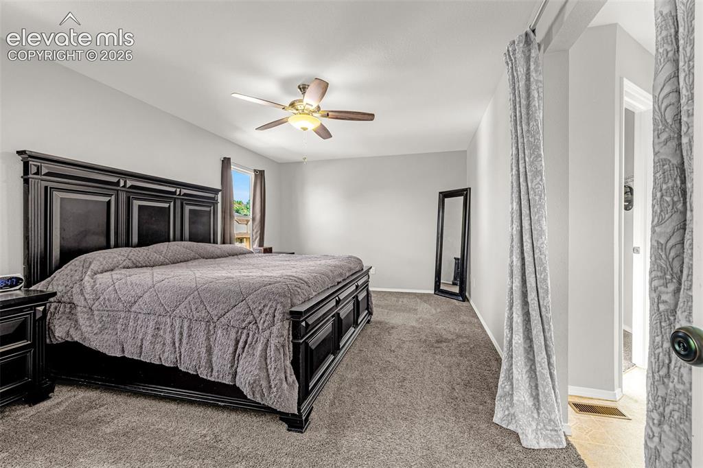 Image 15 of 42: Carpeted sleeping area featuring a vaulted ceiling and a ceiling fan with i