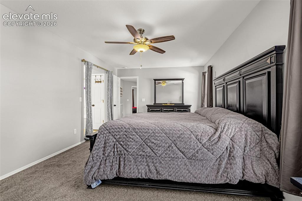 Image 16 of 42: Carpeted bedroom featuring a vaulted ceiling and a ceiling fan with integra