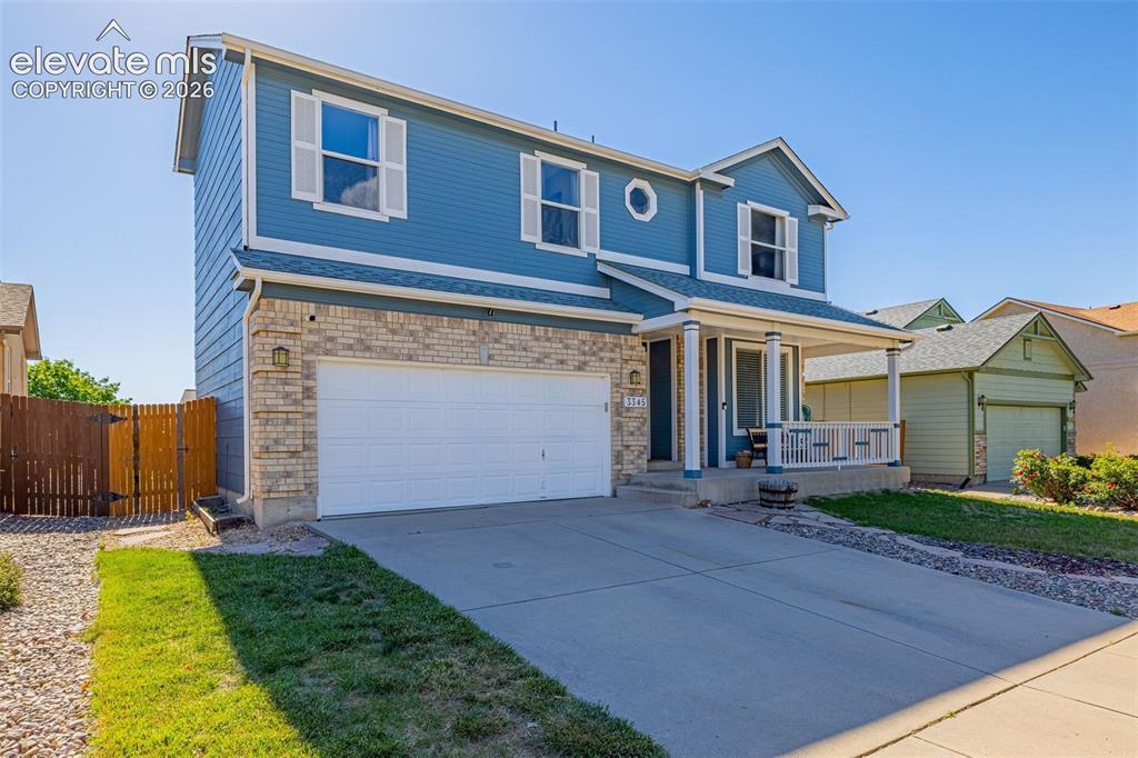 Image 2 of 42: Two-story residence featuring a covered front porch, an attached two-car ga
