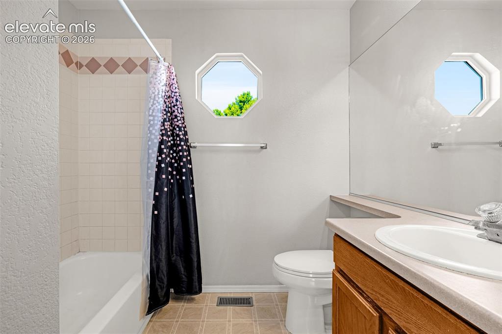 Image 21 of 42: Bathroom featuring a built-in tub with tile surround and decorative accent