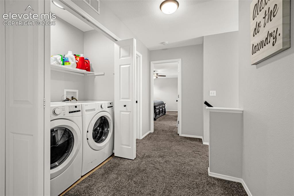 Image 22 of 42: Dedicated laundry closet featuring bi-fold doors and an upper storage shelf