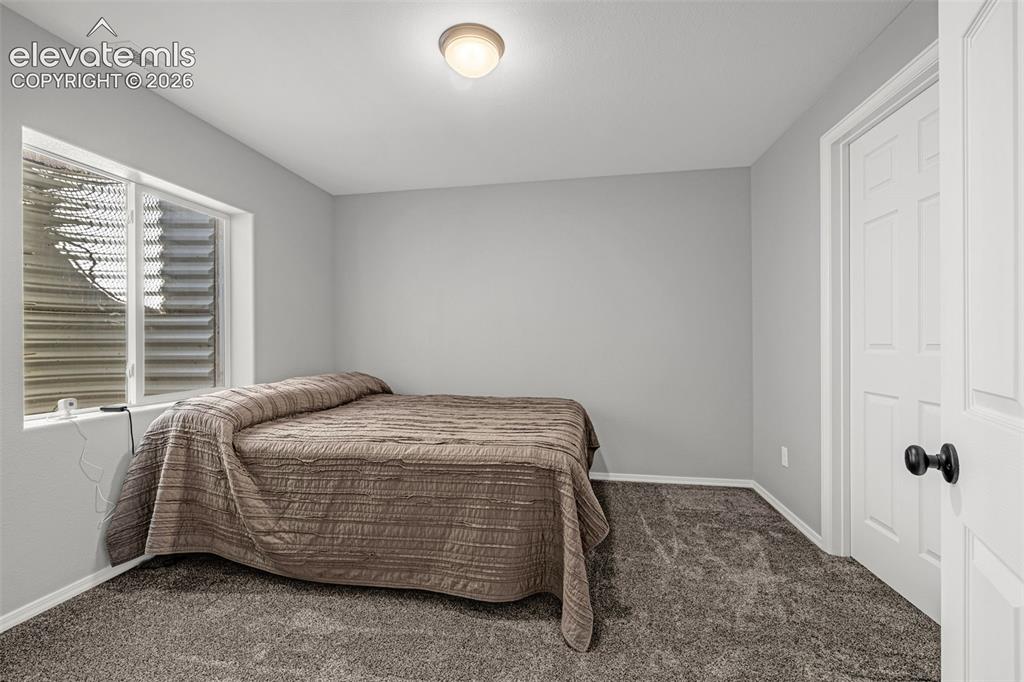 Image 25 of 42: Carpeted room featuring a white interior door with black hardware, a flush-
