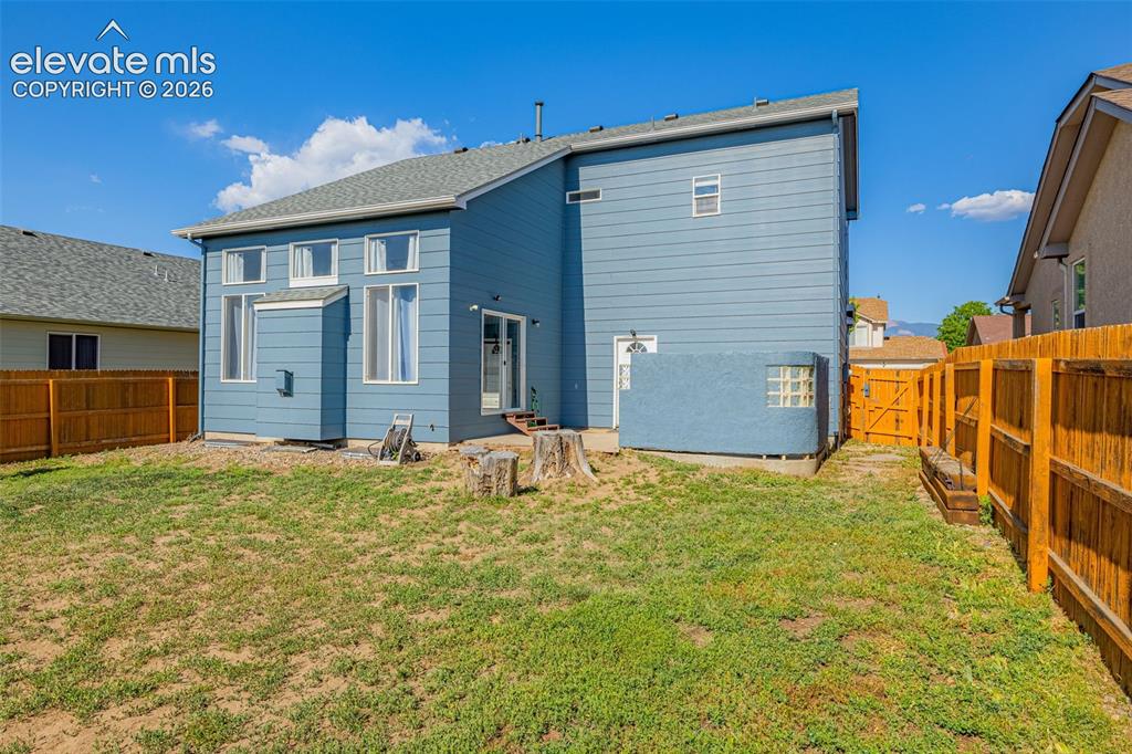 Image 28 of 42: Expansive backyard featuring a partial privacy fence, a glass block window
